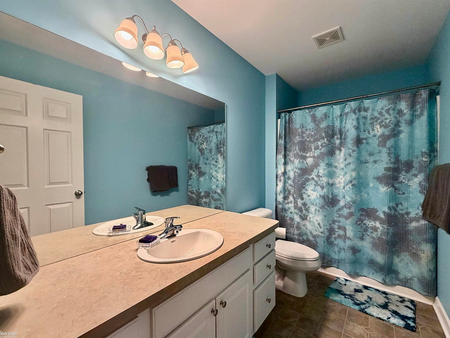 Bathroom with turquoise walls and white vanity