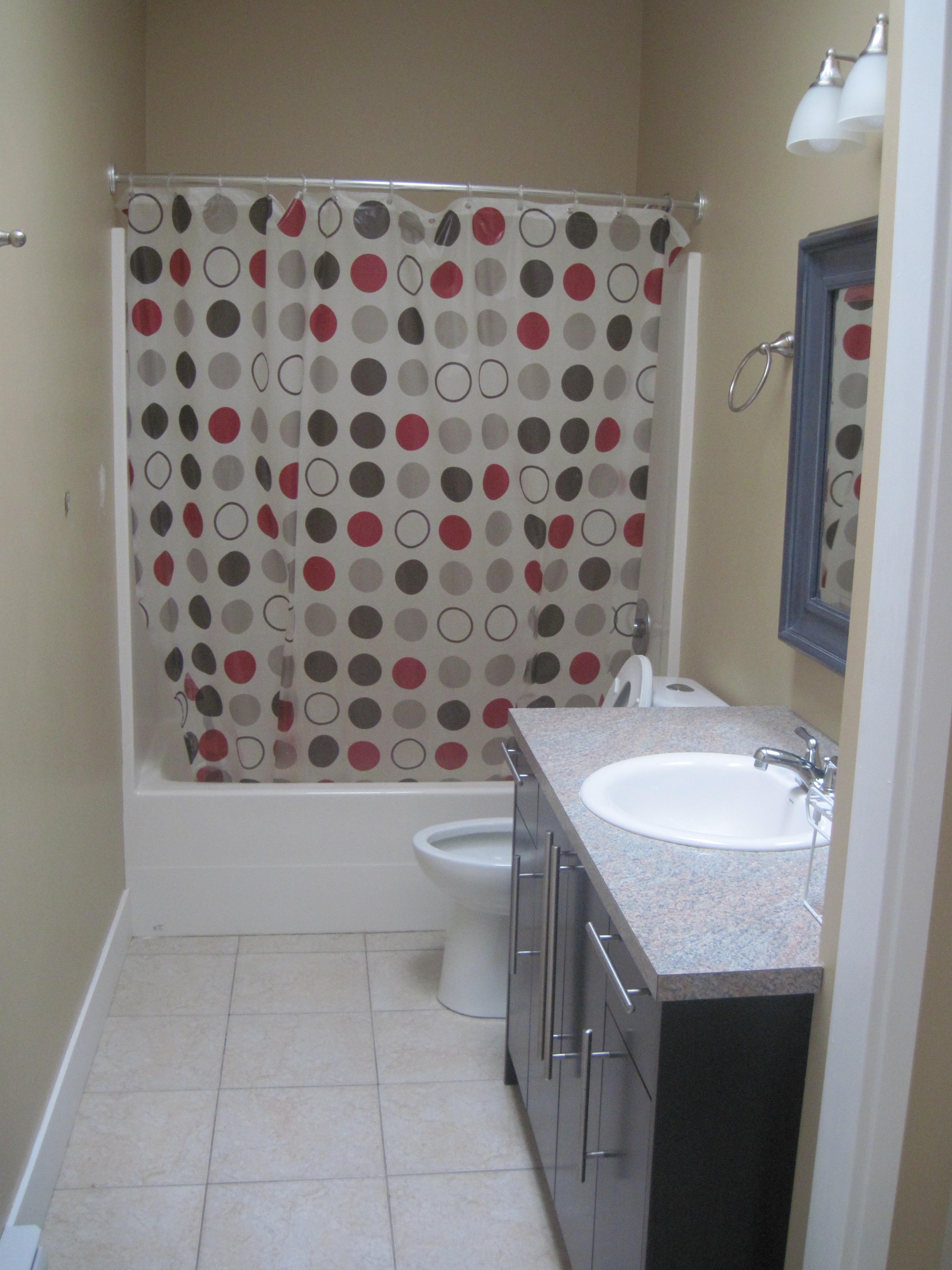 Bathroom with dark wood-grain vanity and grey countertop