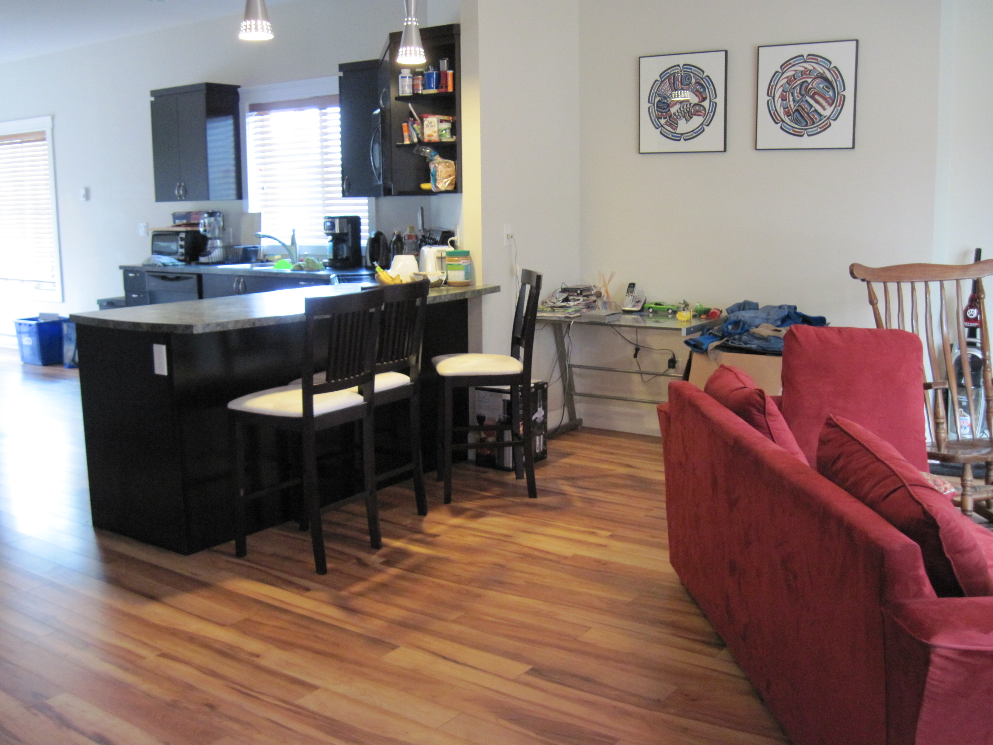 Sunlit open-concept kitchen and transition space highlighting spacious island structure