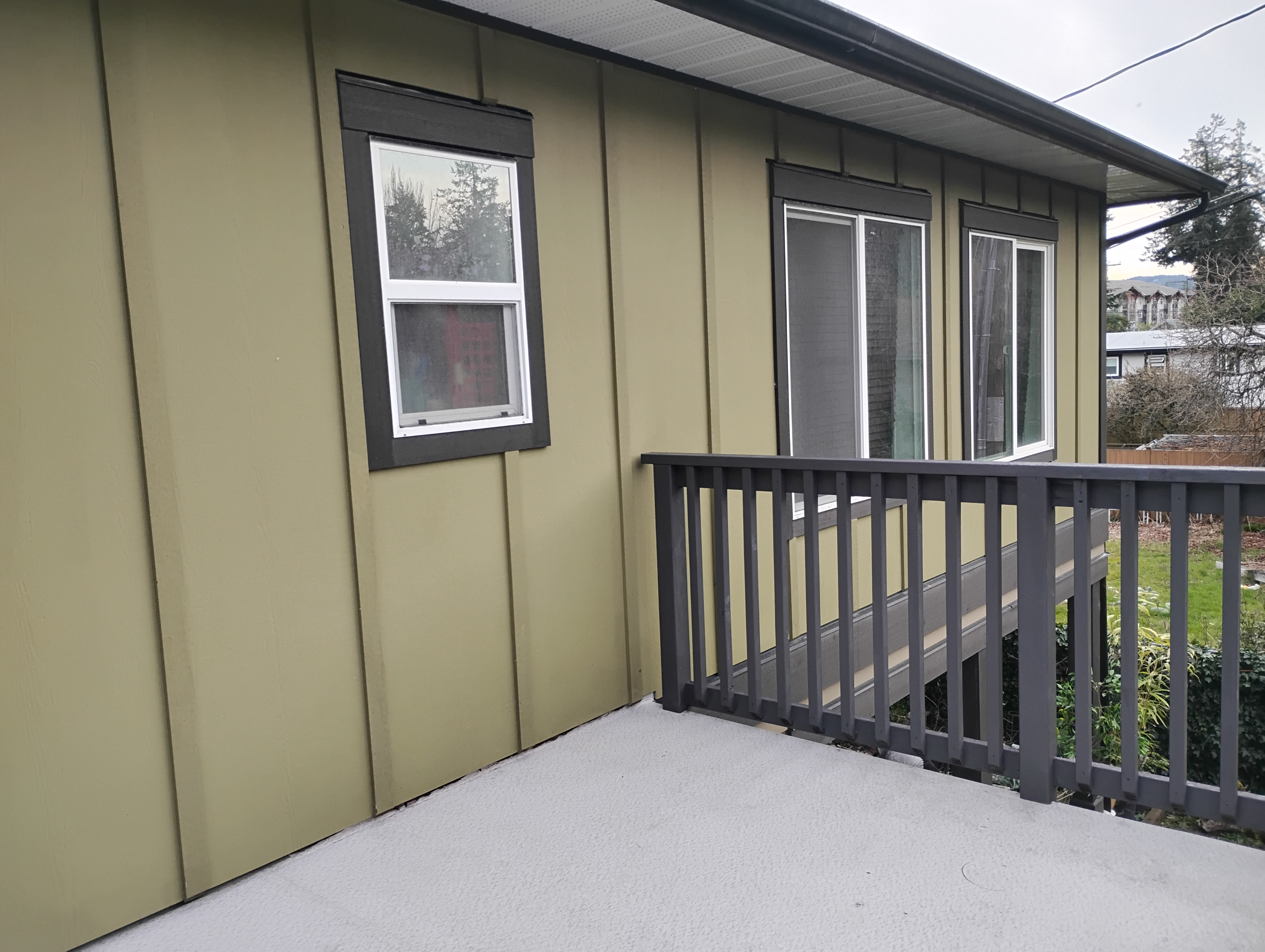 Wide wooden timber deck overlooks quiet safe residential yard spaces