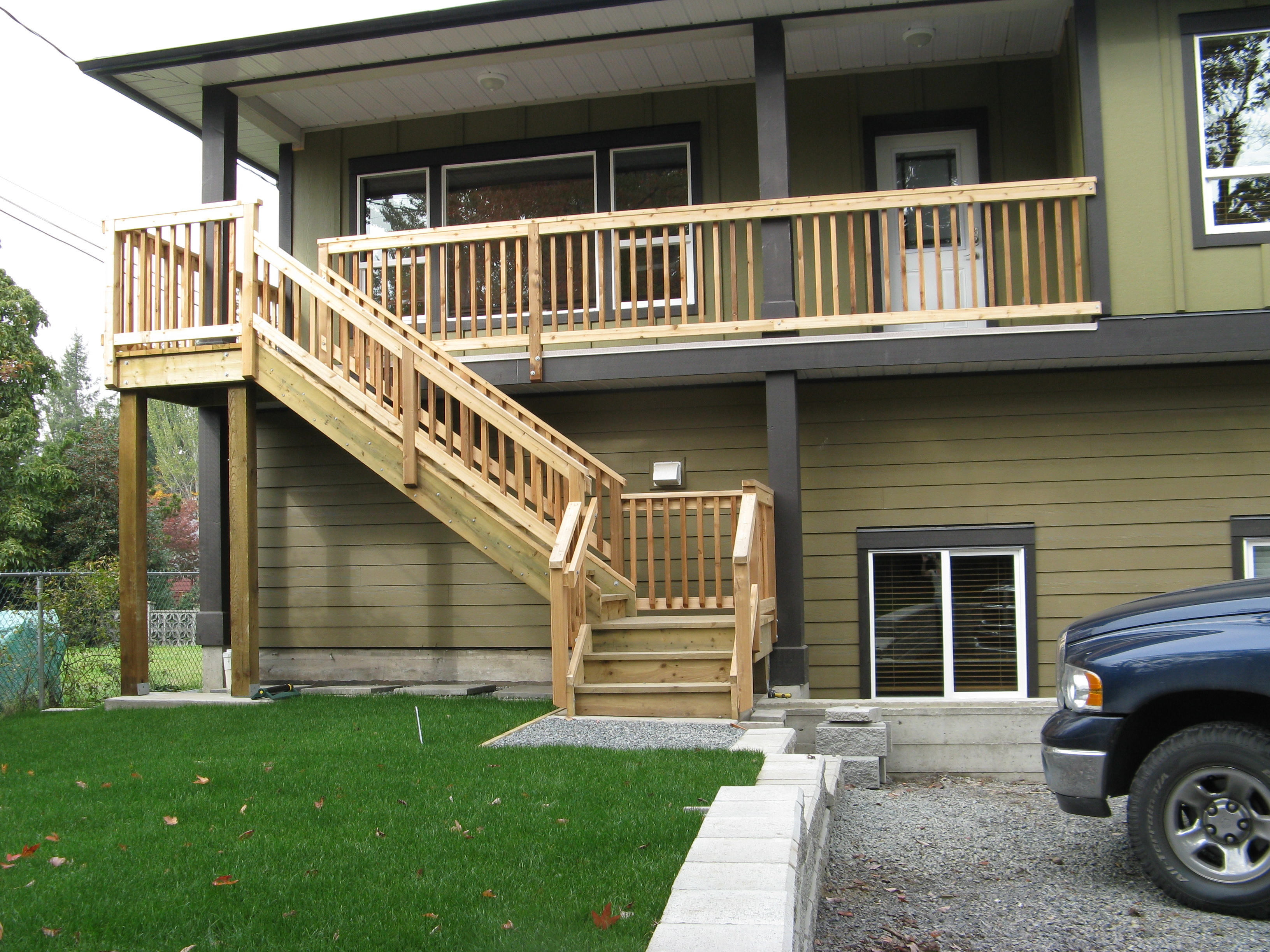 Durable split-level exterior details with wood stairways and gravel driveway