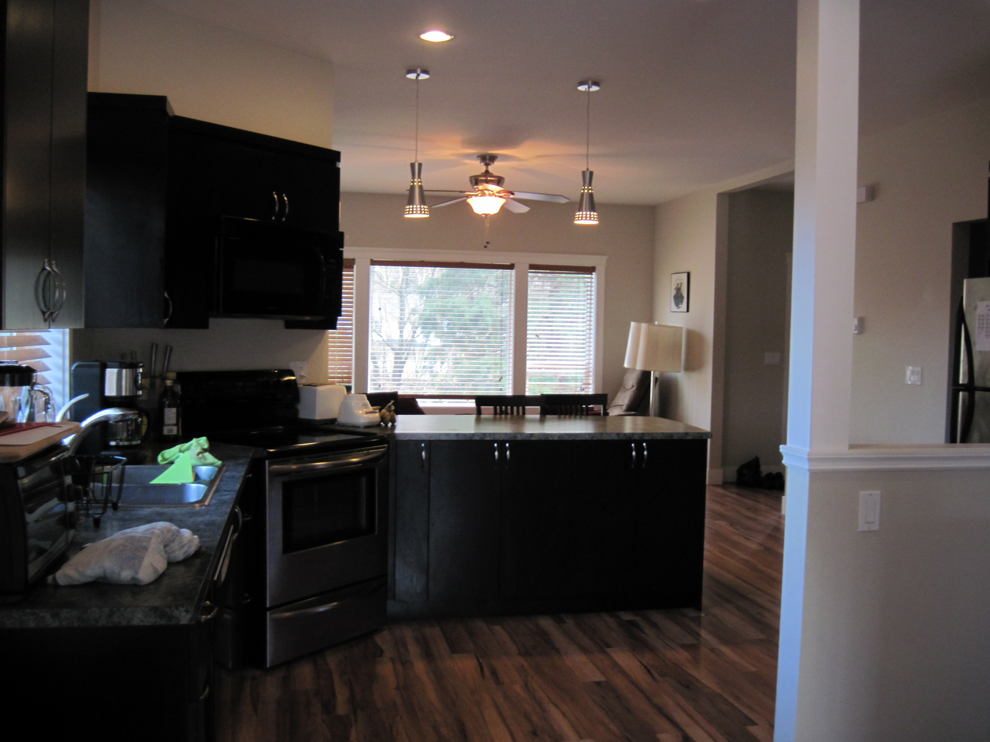 Kitchen with dark flat-panel cabinetry and island looking toward dining area
