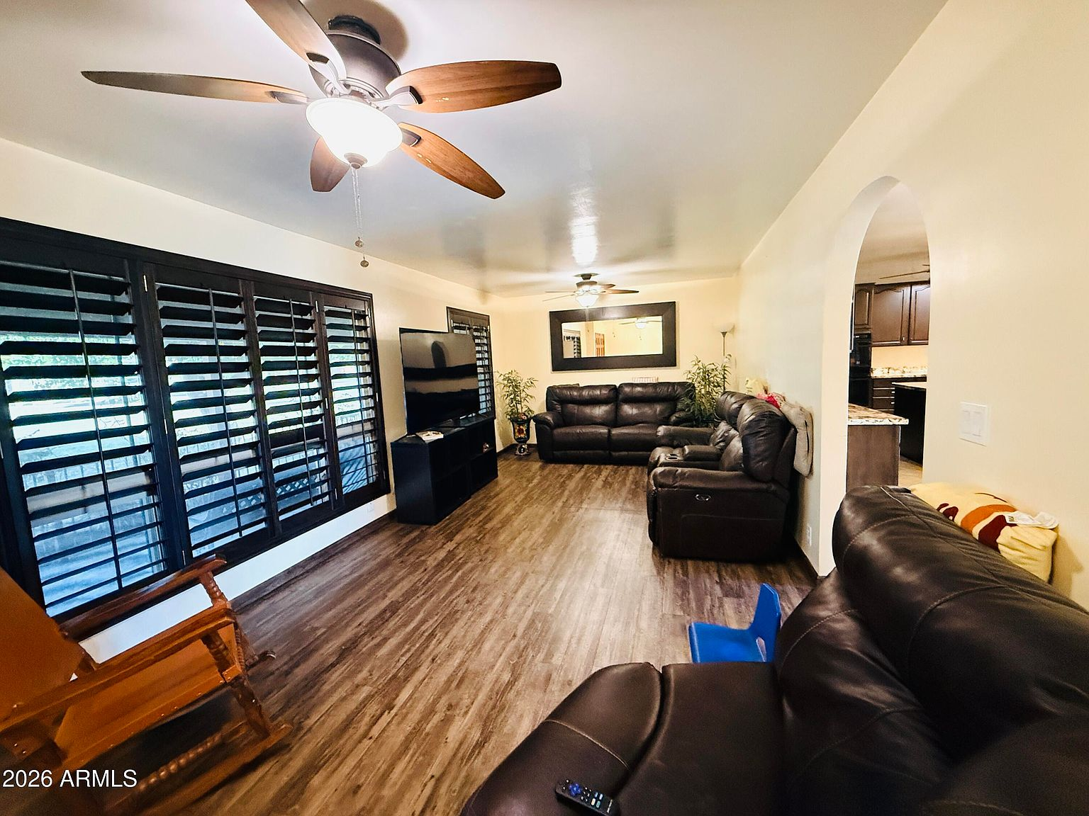 Living room with plantation shutters and arched entryway