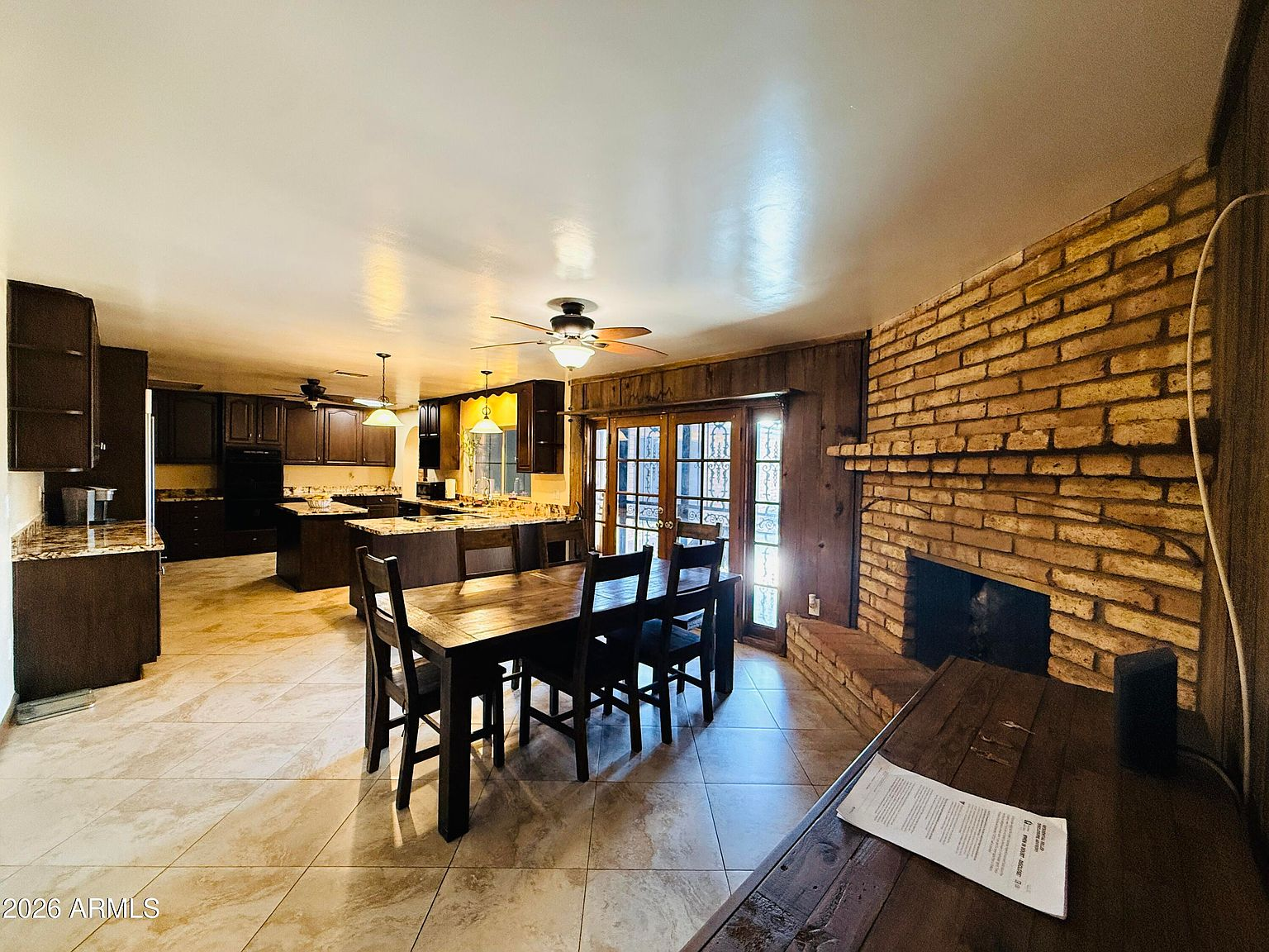 Dining area adjacent to kitchen with brick fireplace
