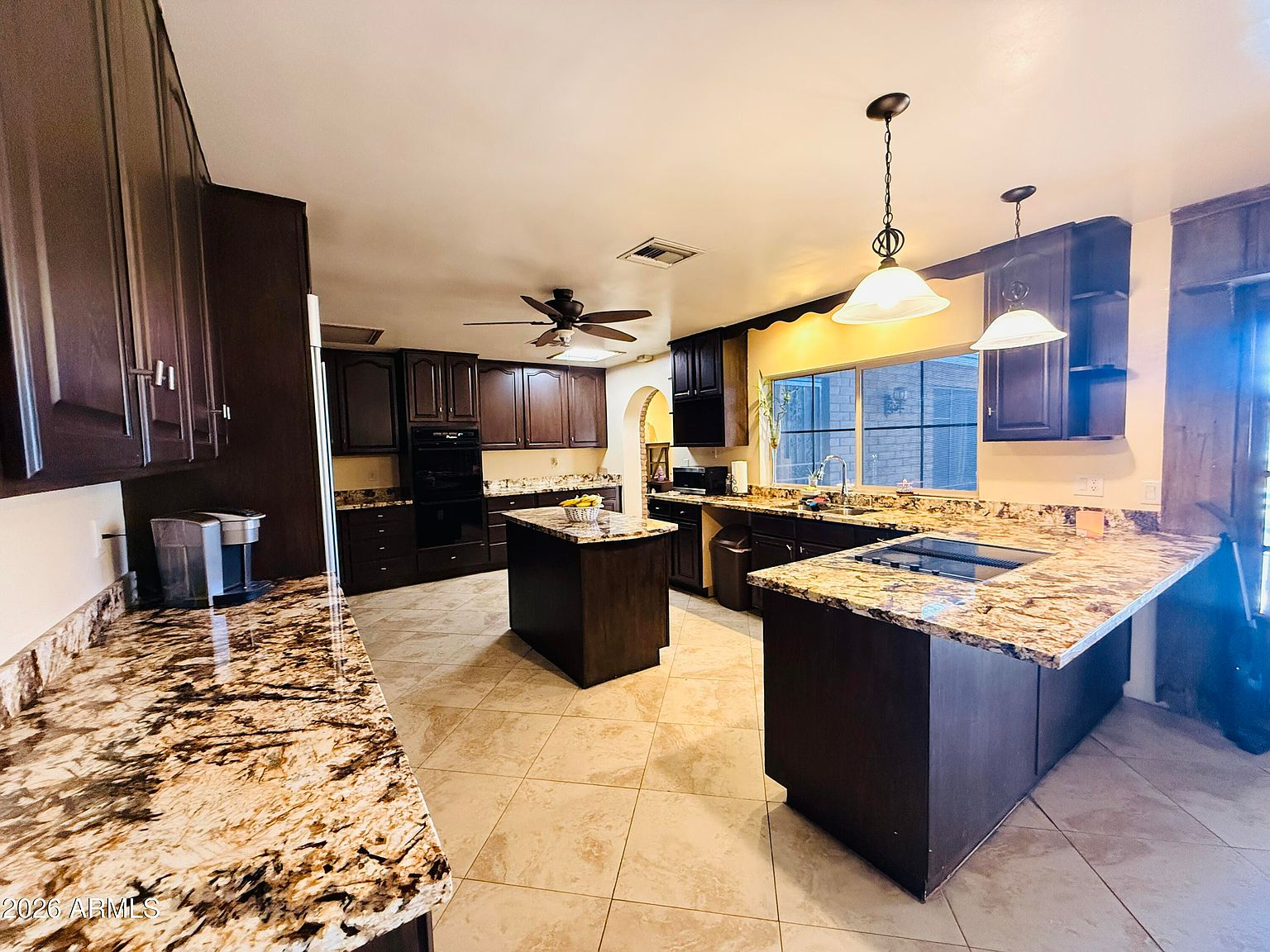 Kitchen with granite countertops and dark wood cabinetry