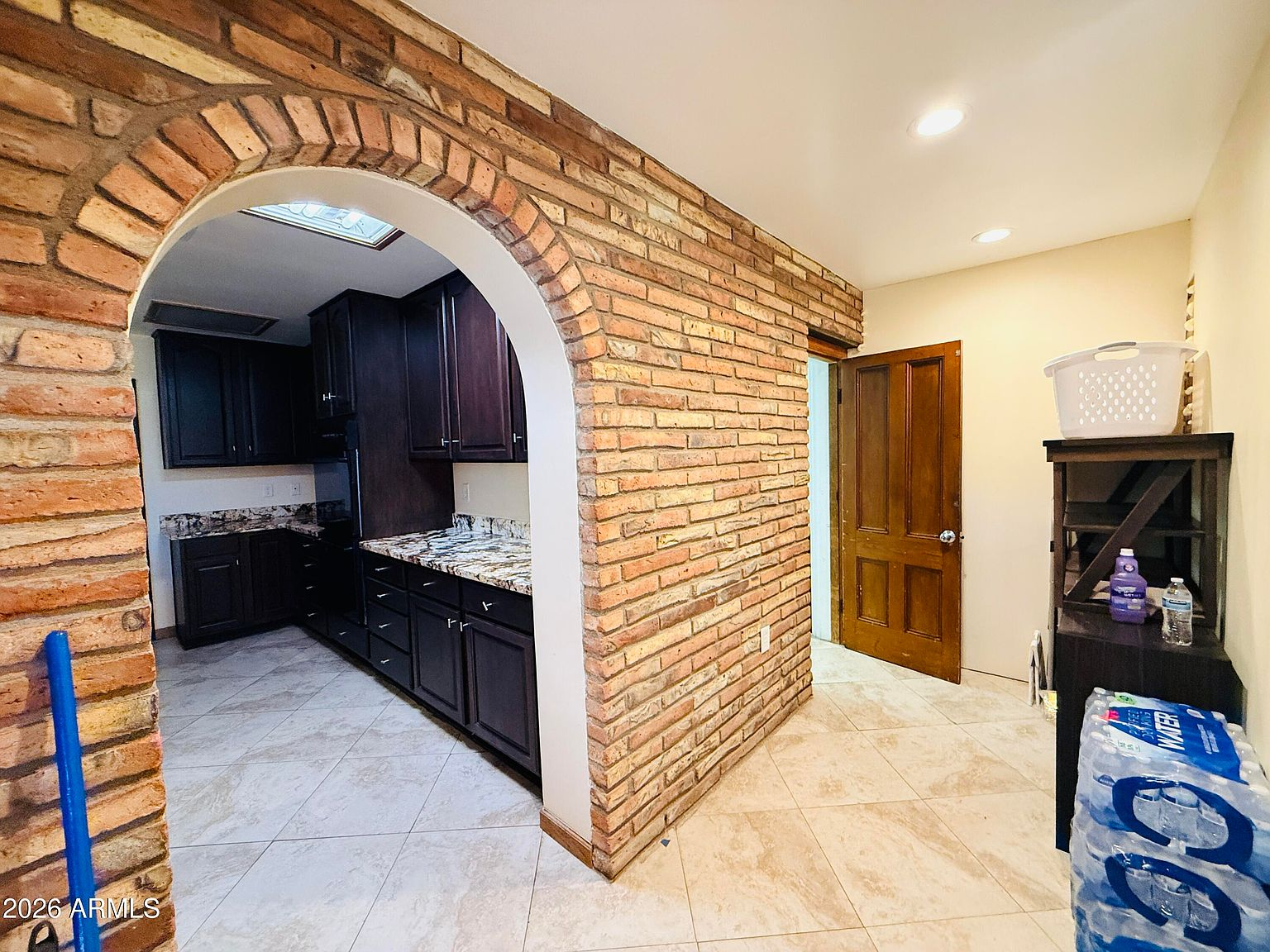 View through brick archway into secondary kitchen