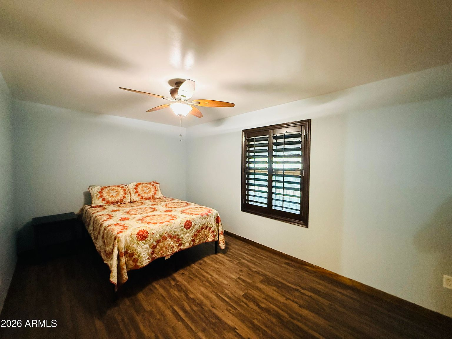 Bedroom with light blue walls and wood-look flooring