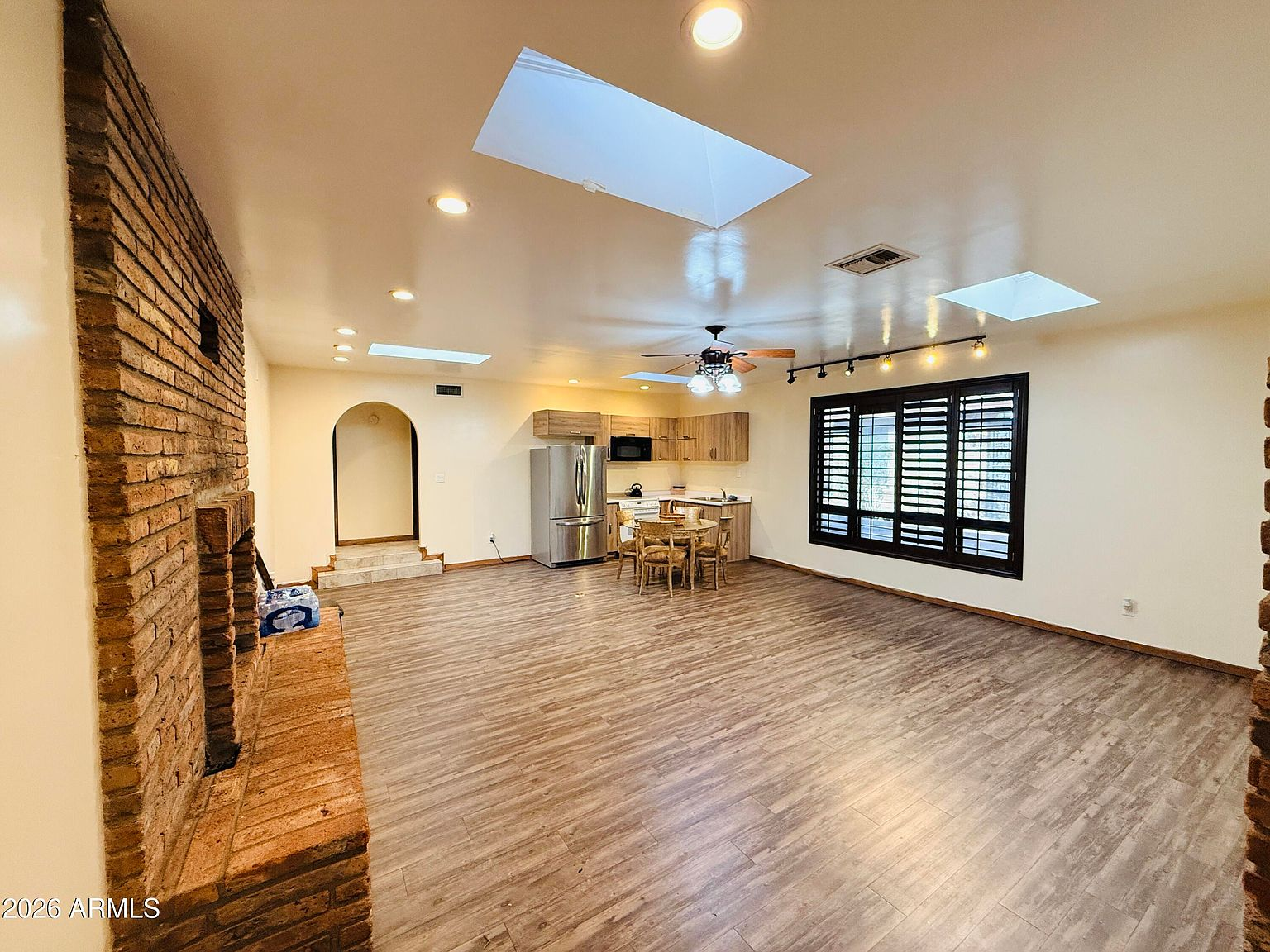 Great room with exposed brick fireplace and skylights
