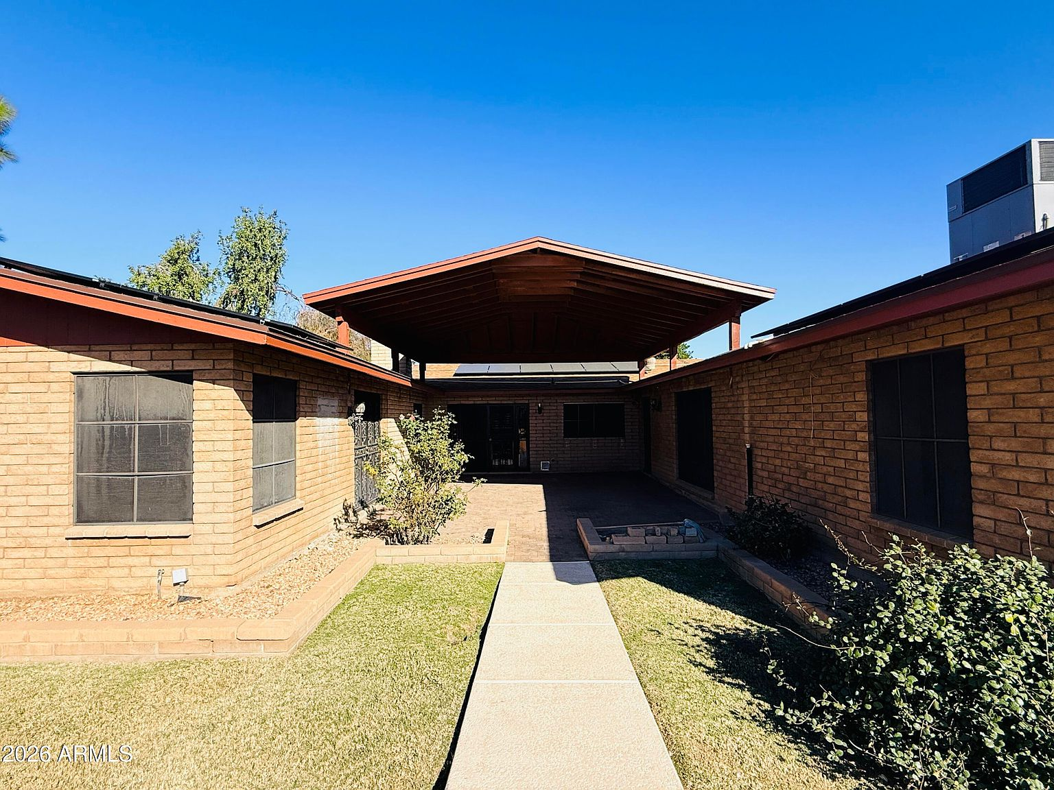 Covered breezeway and carport with brick exterior