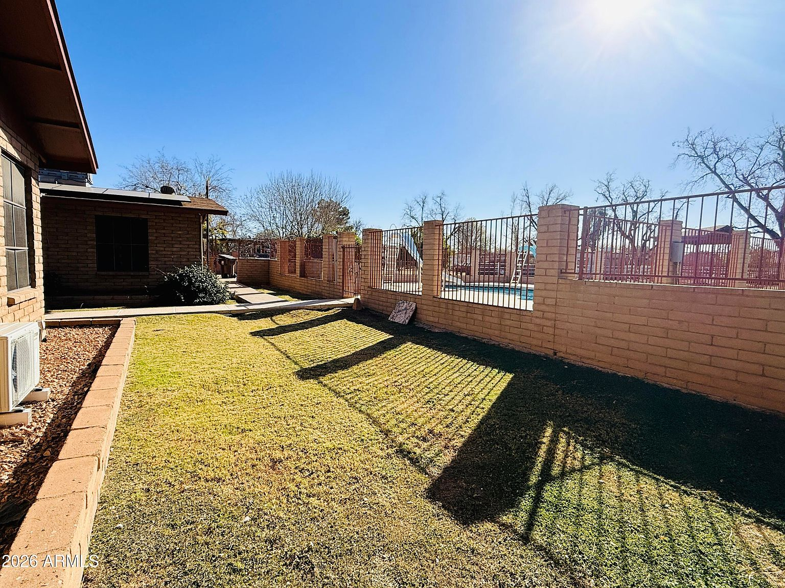 Backyard with grass lawn and fenced pool