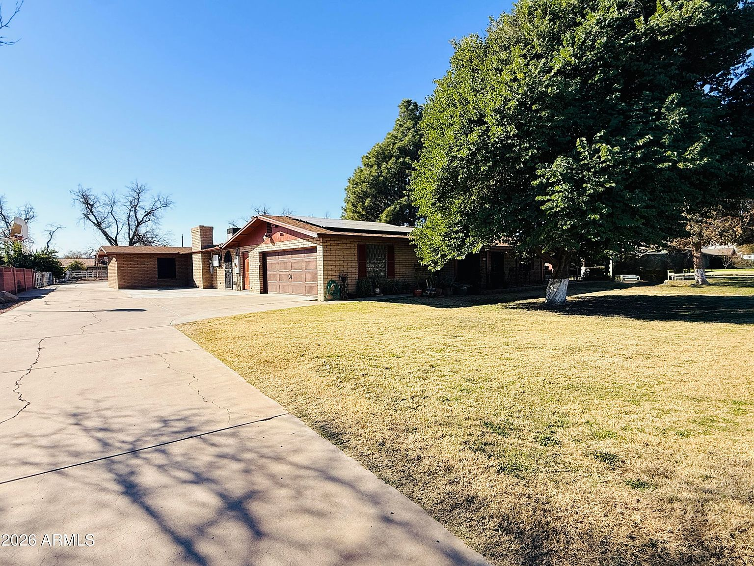 Front facade with driveway and mature shade trees