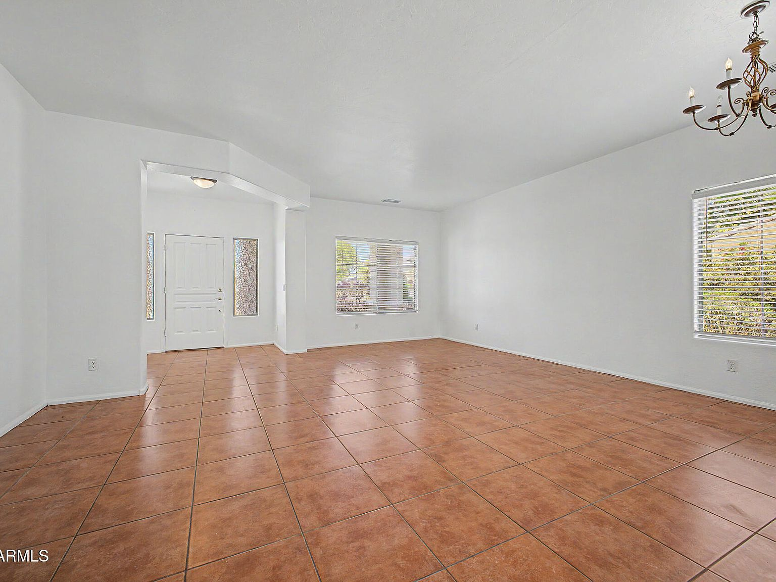Formal living and entry area with terracotta tile flooring and vaulted ceilings