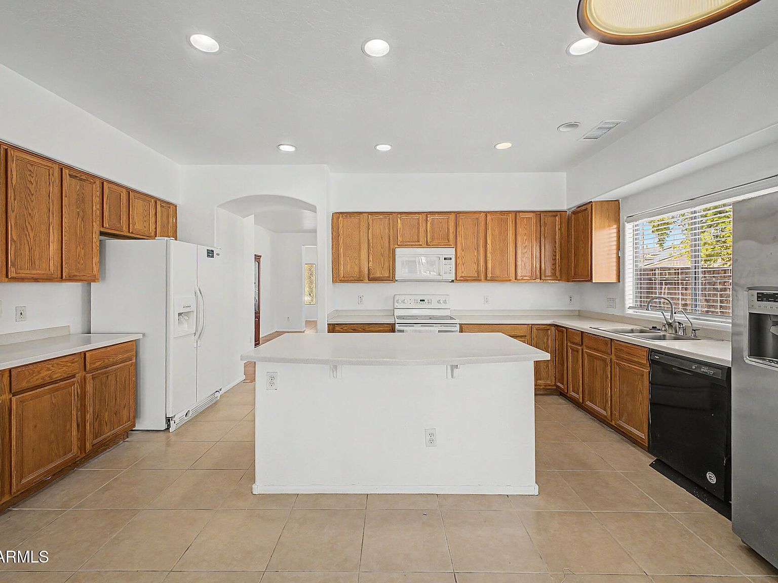 Kitchen island view with built-in appliances and recessed lighting