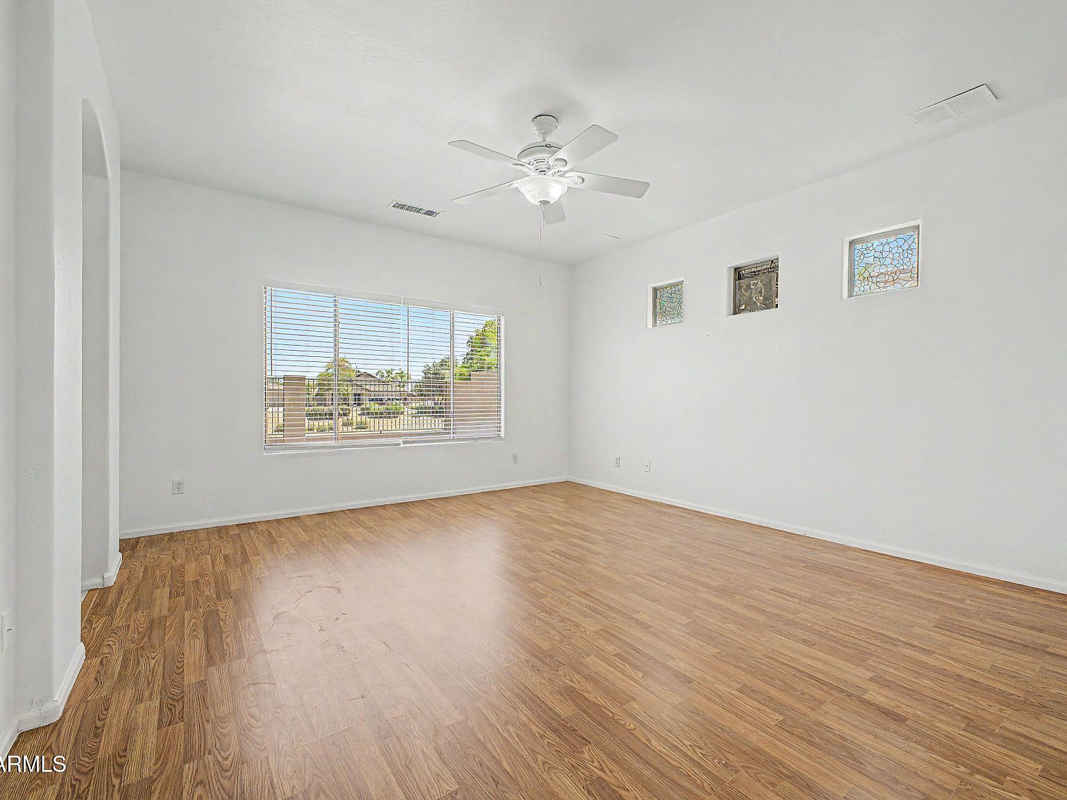 Living room with wood-look flooring and arched entry detail