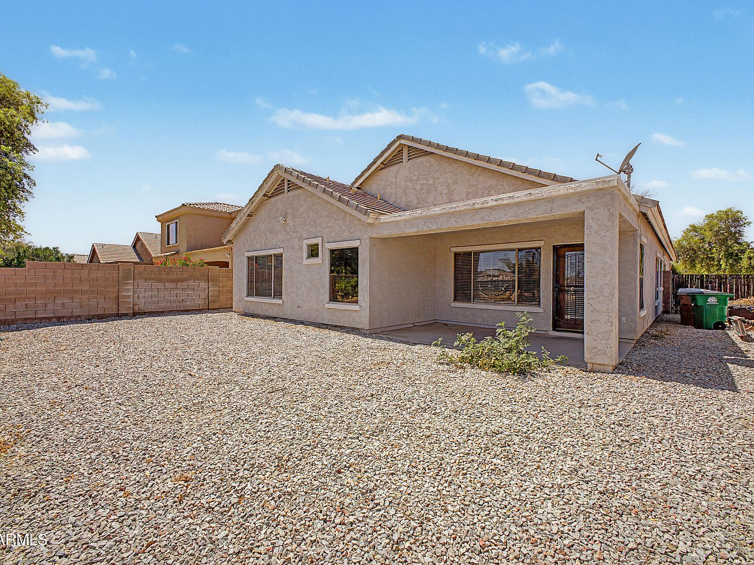 Backyard exterior showing covered patio and stucco home exterior