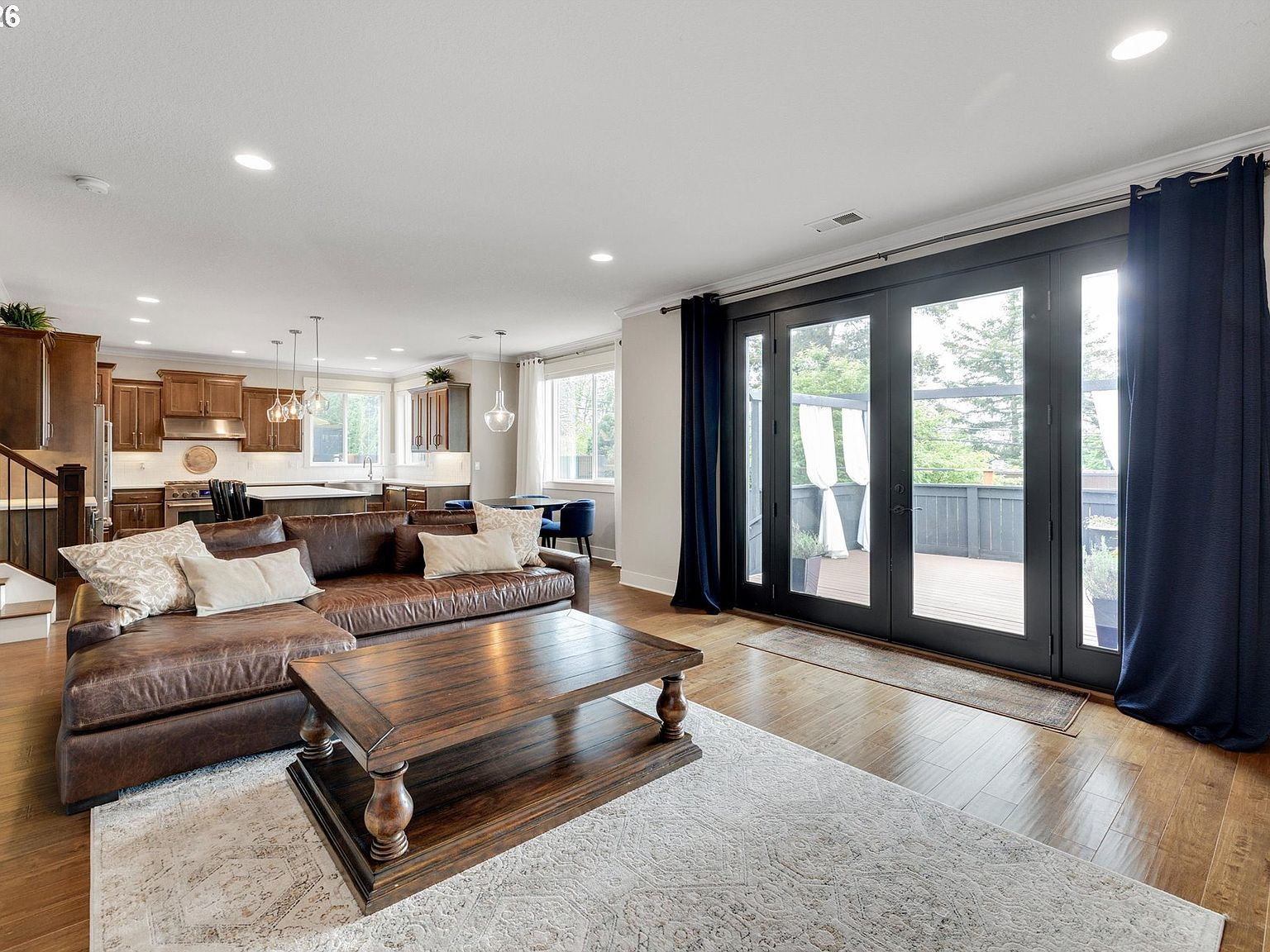Living room looking out through double glass doors showing the elevated backyard pergola deck