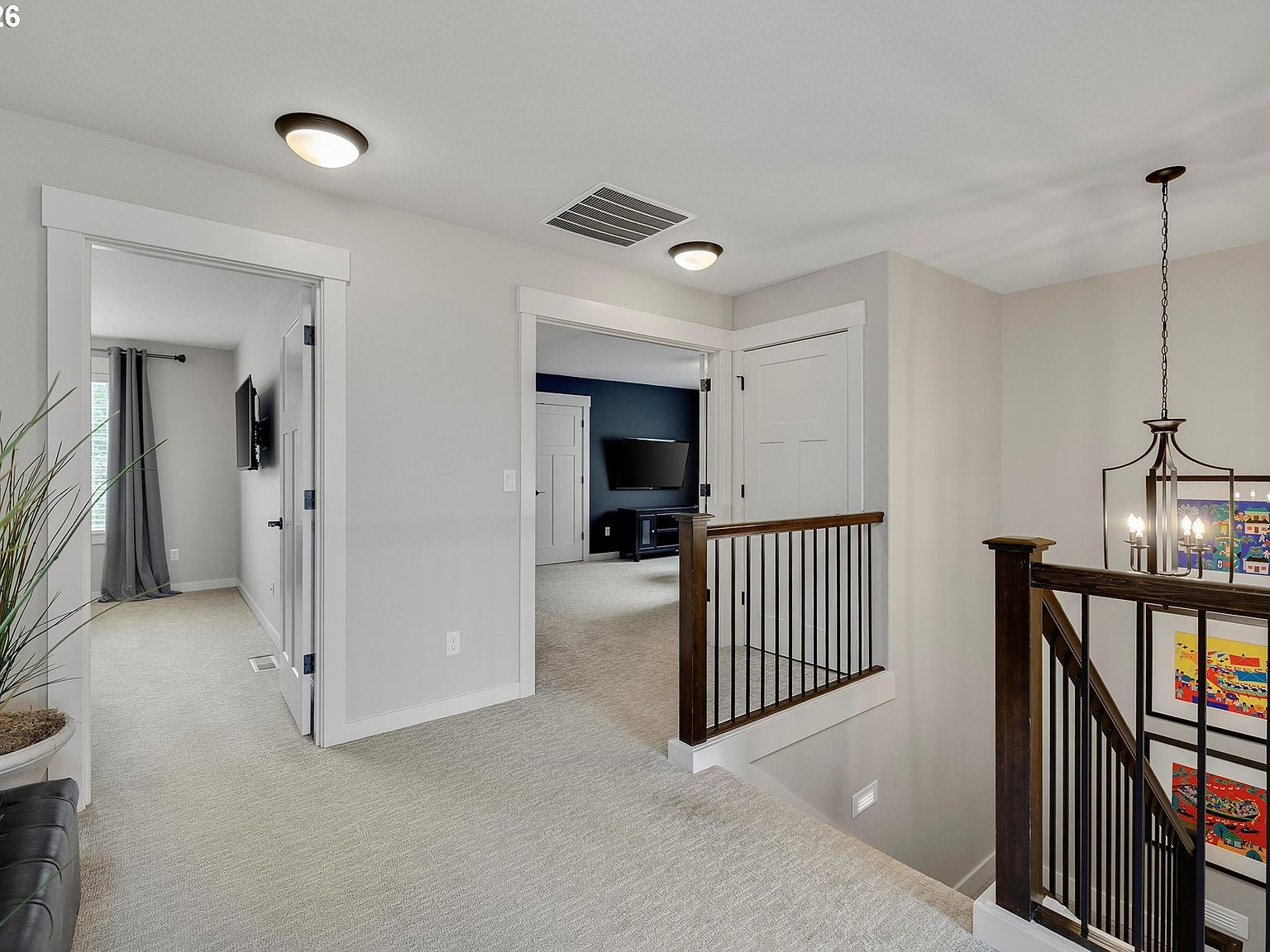 Staircase railing over top of double-volume entryway showing staircase with black iron spindles
