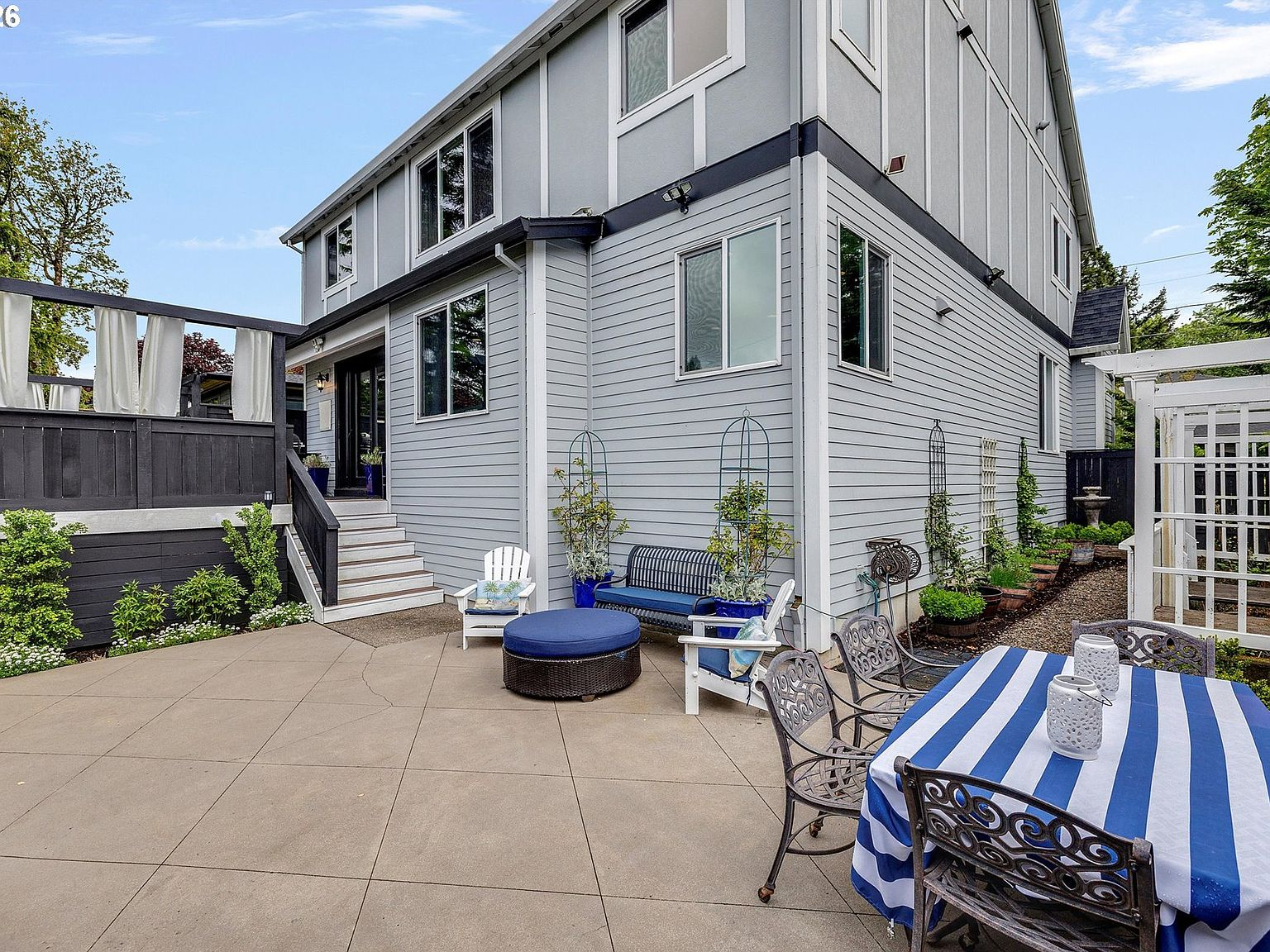 Fully fenced backyard featuring a sunken concrete patio and raised garden beds