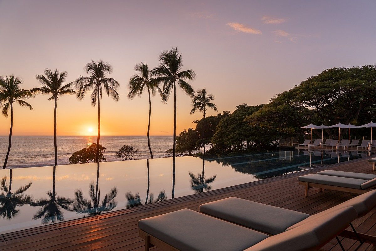 Mauna Kea Beach Resort shared infinity pool under a brilliant golden sky.