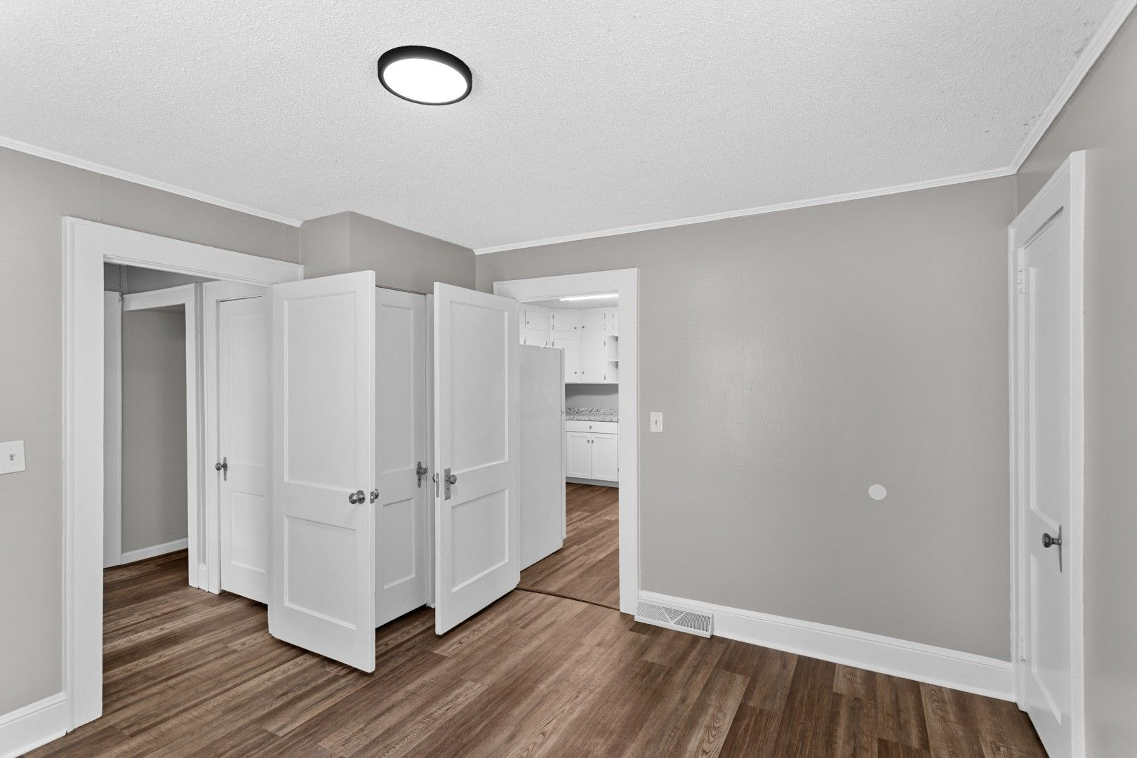 Pristine central hallway leading towards pristine white wardrobe doors