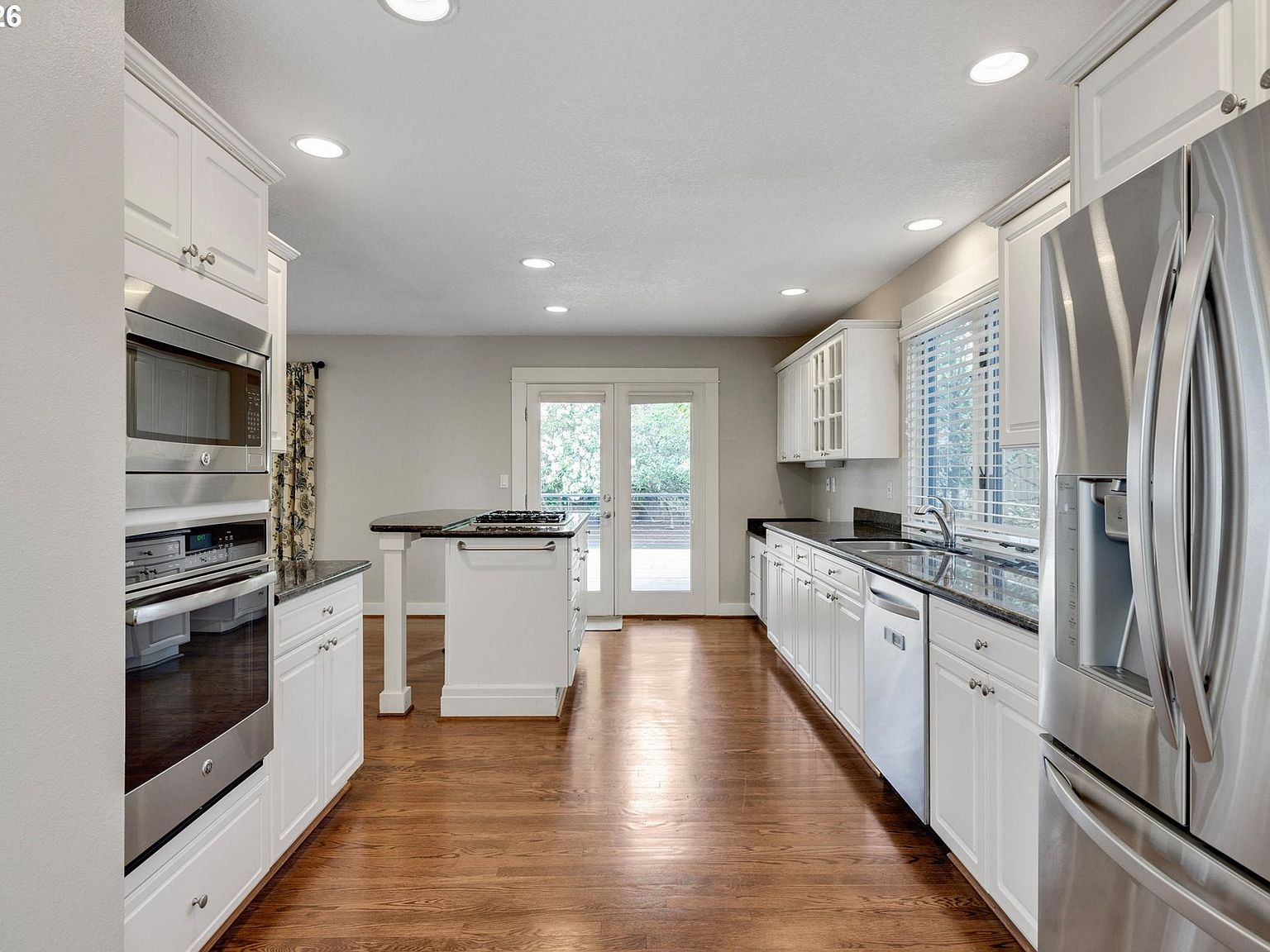 Kitchen with white cabinetry and dark granite countertops