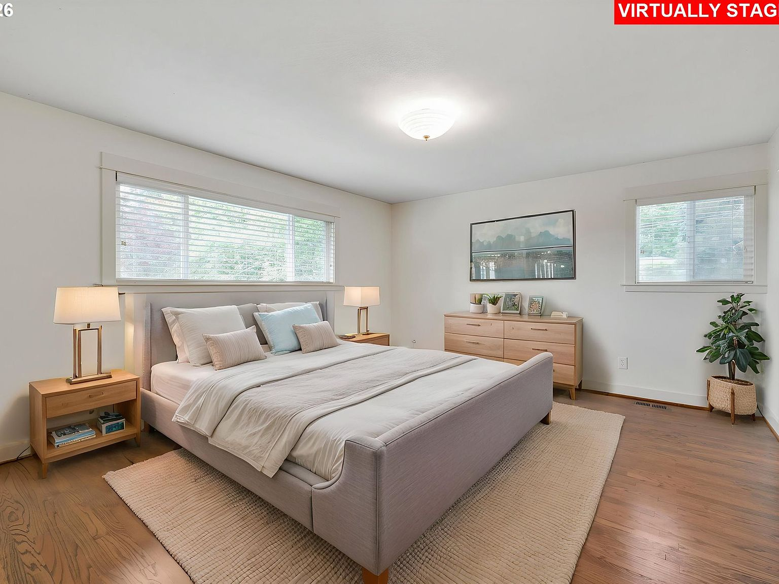 Master bedroom with hardwood floors and natural light