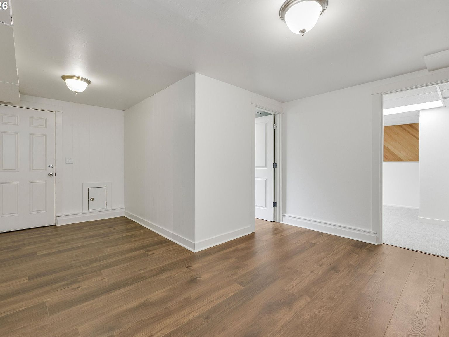 Renovated basement room with new wood laminate flooring