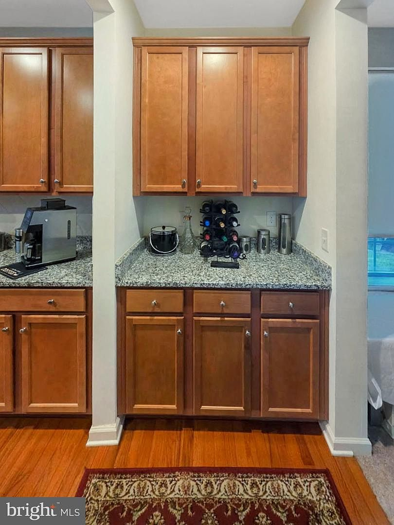 The custom butler pantry nook with granite countertops and upper cabinetry