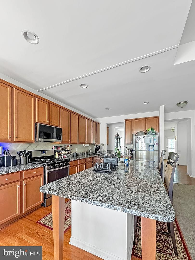 Close-up of the kitchen workspace showcasing speckled granite countertops, built-in dual sink, and hardwood flooring