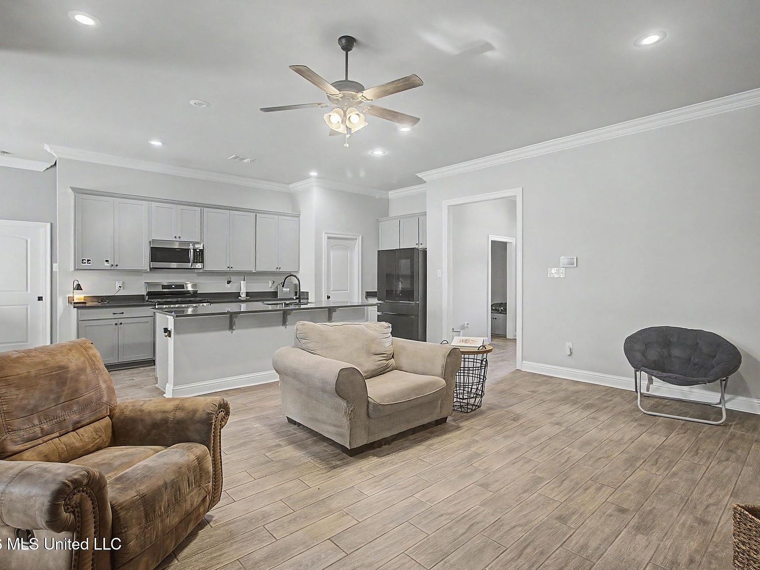 Bright open-concept living area with seamless view to kitchen and ceramic tile flooring
