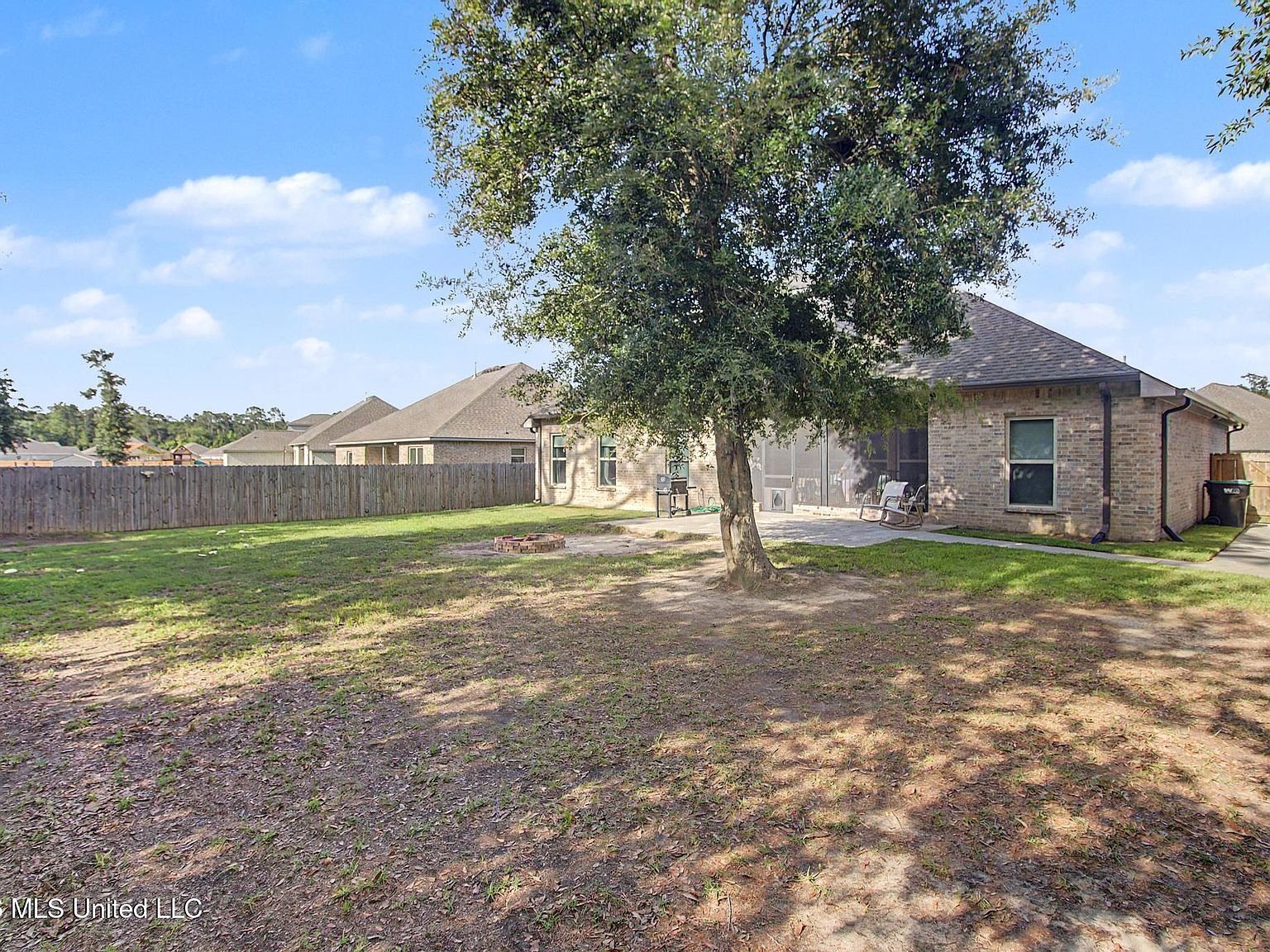 Privacy-fenced backyard detailing a well-kept lawn and a wooden board boundary