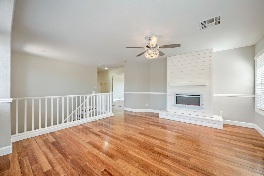 Spacious loft living room featuring a custom shiplap fireplace insert