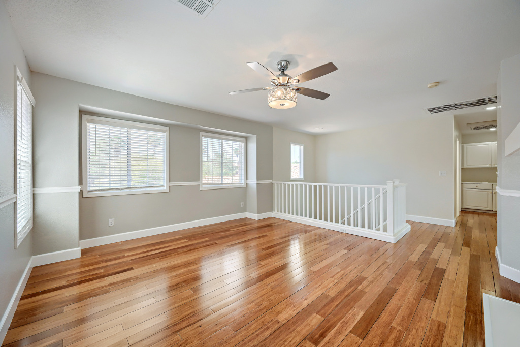 Upstairs multi-purpose loft with polished flooring and wall trim molding
