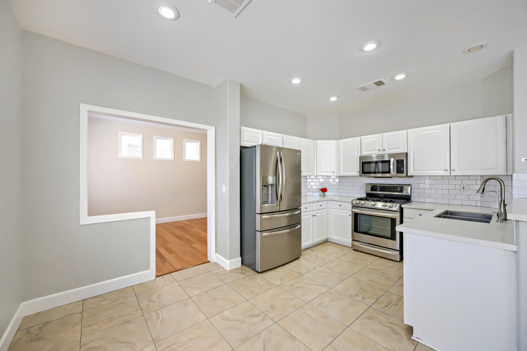 Modern transition kitchen with white shaker cabinetry and stainless appliances