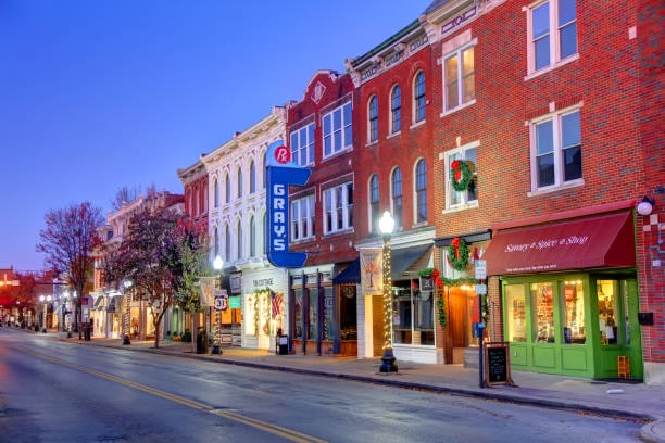 Historic downtown Franklin main street at dusk with illuminated brick storefronts and warm streetlights