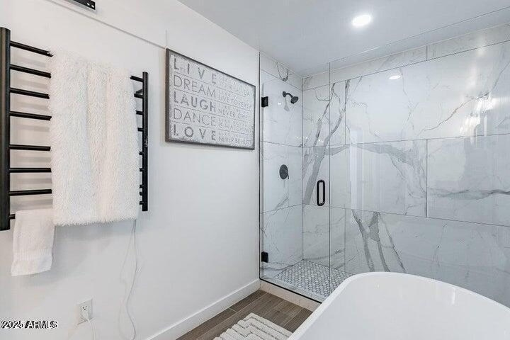 Walk-in shower en-suite with custom marble-look tile walls, penny hex-tiles, and premium black hardware