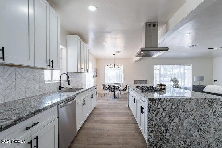 Custom gourmet kitchen looking toward dining room featuring white shaker cabinets, premium granite countertops, and black hardware
