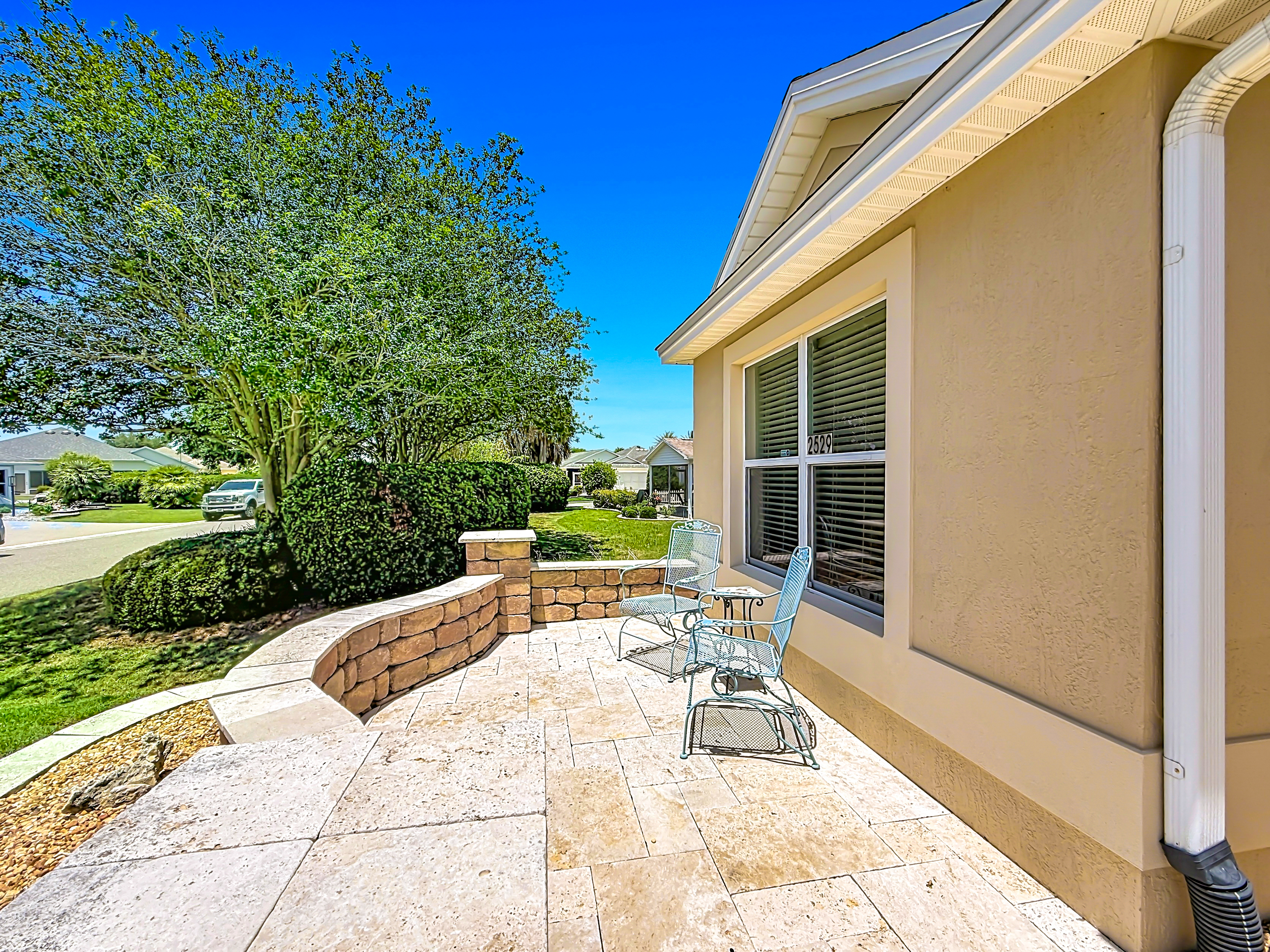 Front patio with stone pavers and tiered planter wall