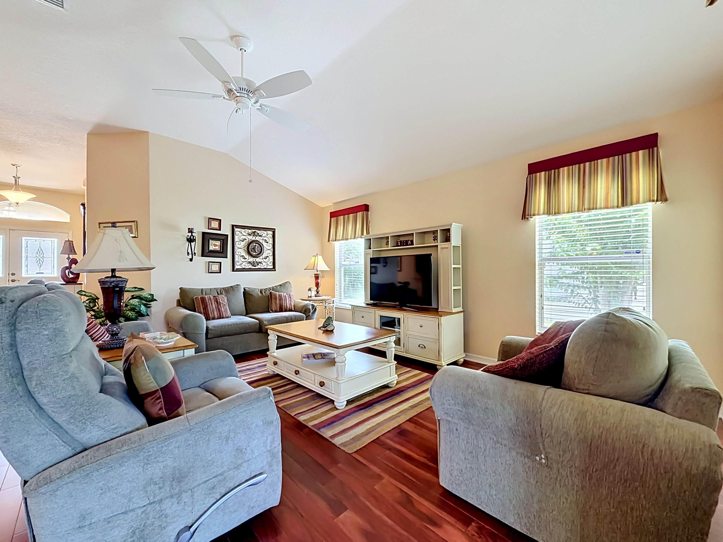 Open-concept living room with vaulted ceilings and hardwood flooring at 2529 Edenville Path The Villages