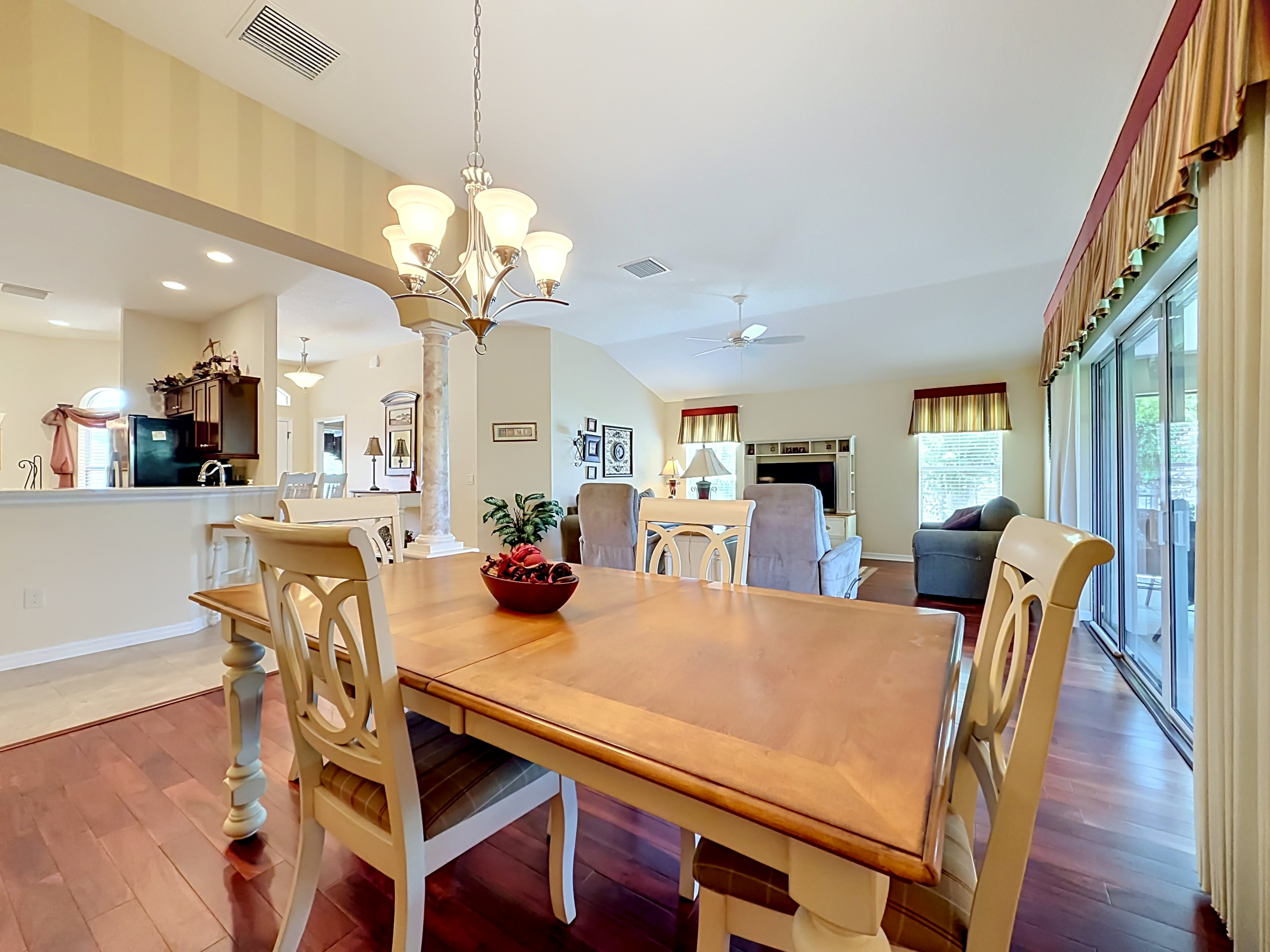 Open-concept dining and living area with hardwood floors and vaulted ceilings