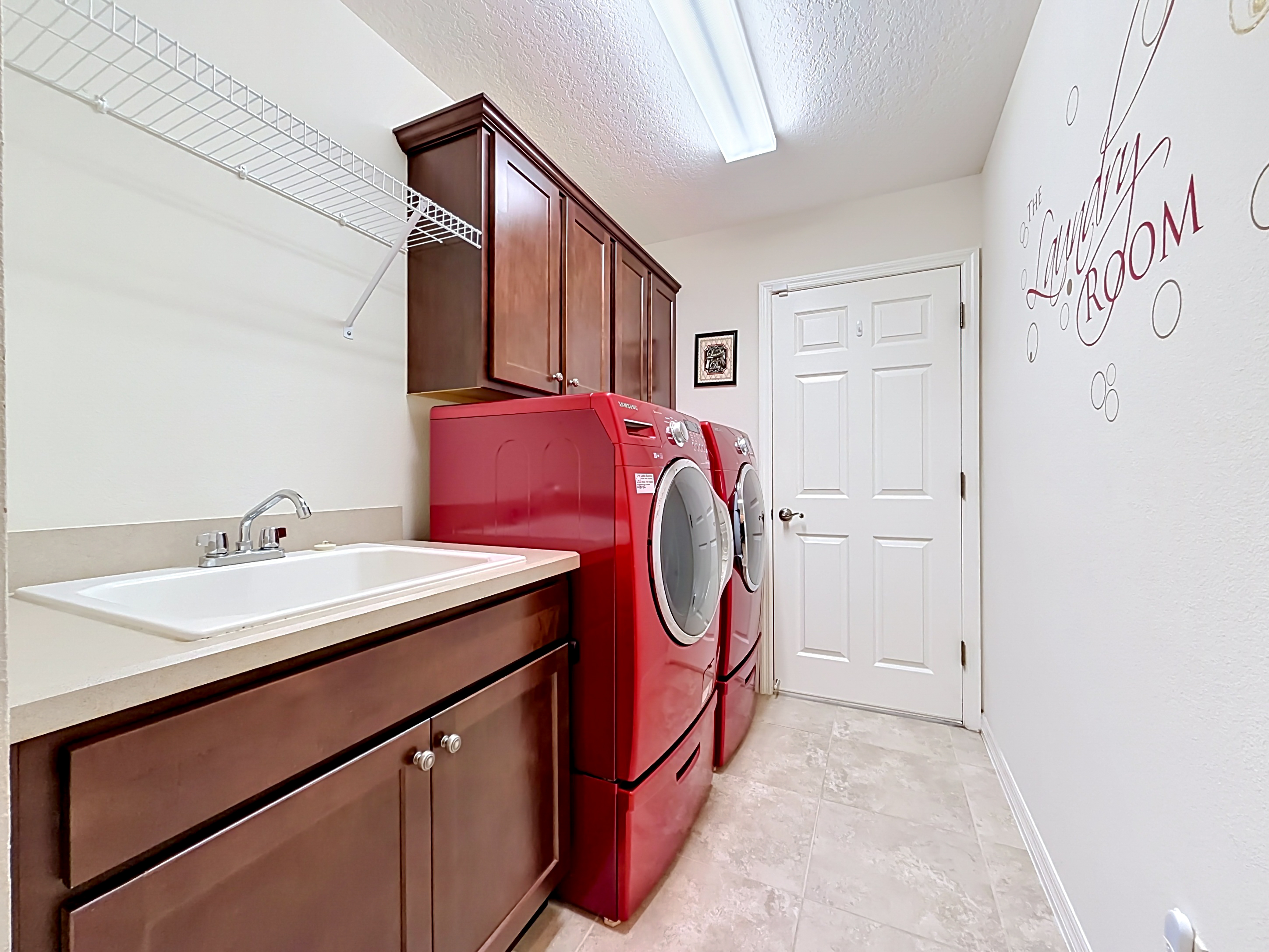 Laundry room with utility sink and dark cabinetry