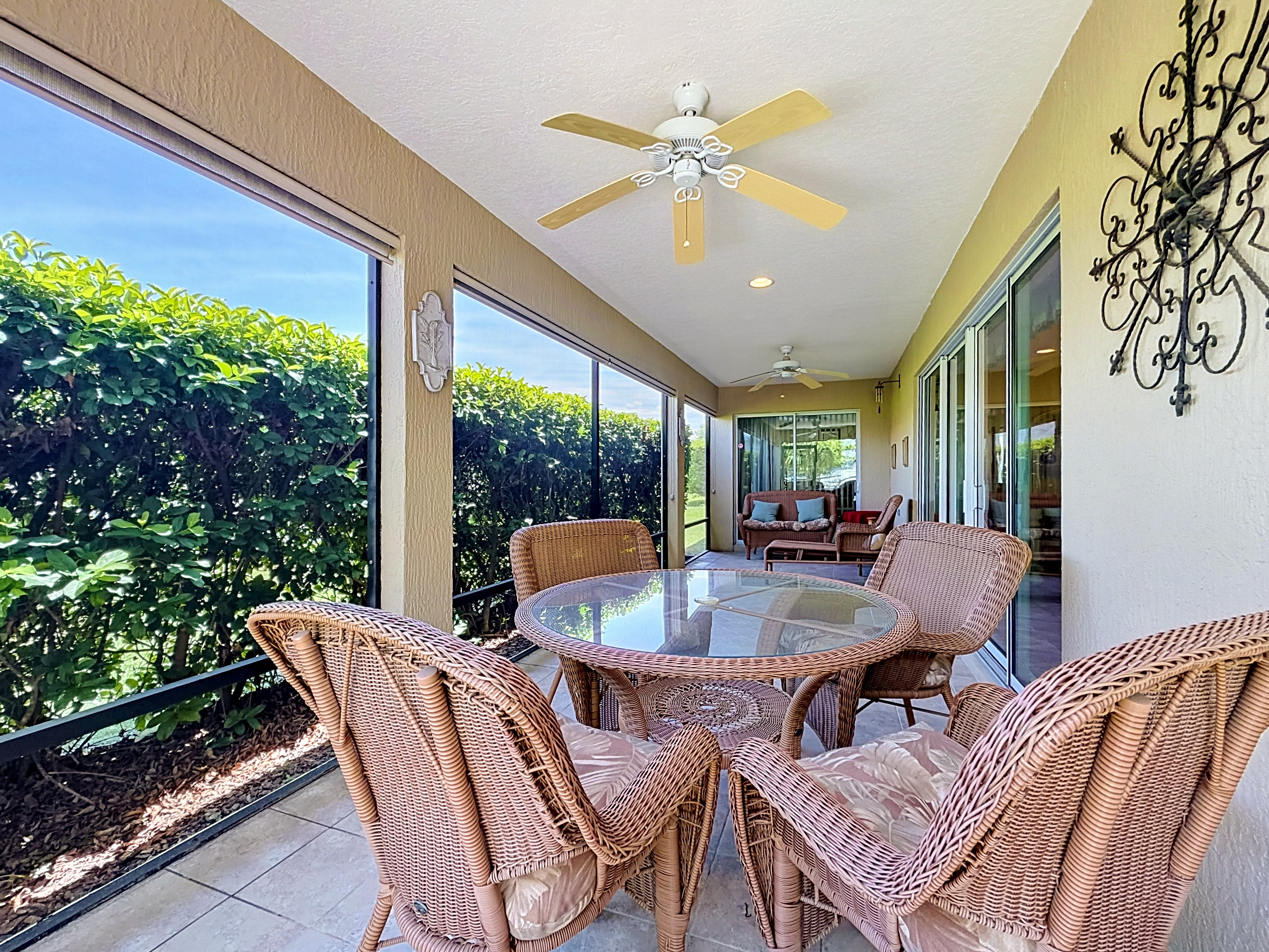 Screened-in back porch with outdoor dining set and seating area overlooking the backyard