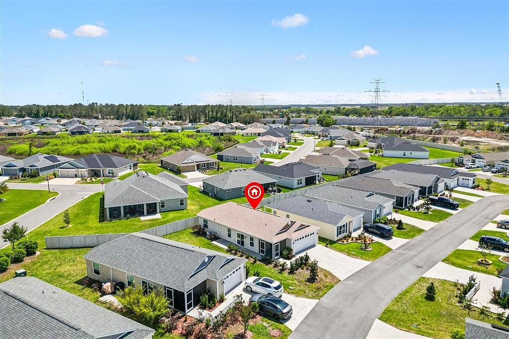 Drone aerial view of The Villages FL neighborhood near 7185 Fay Ct showing villa rooftops and tree-lined streets