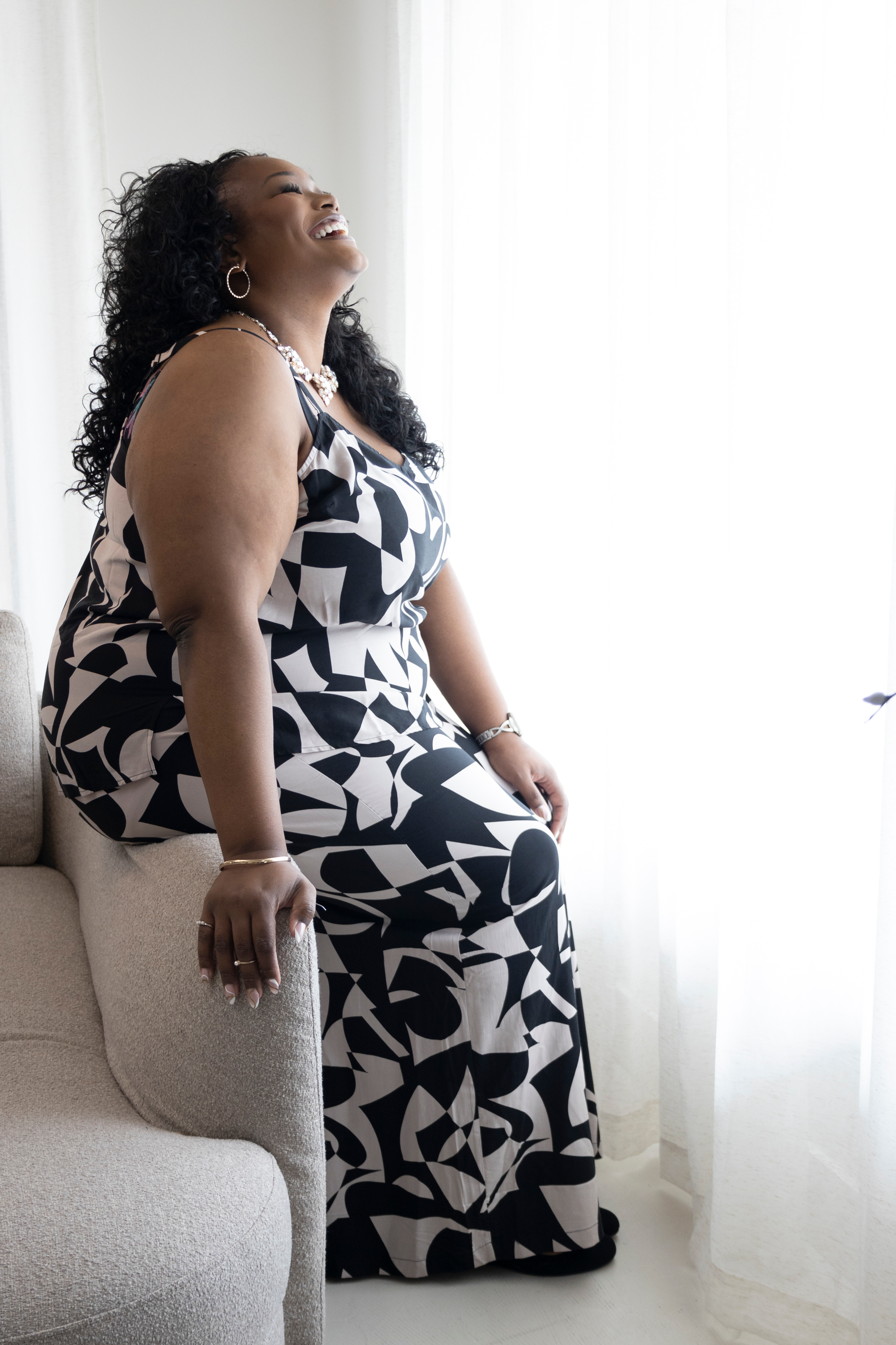 Tory Akene laughing at a window