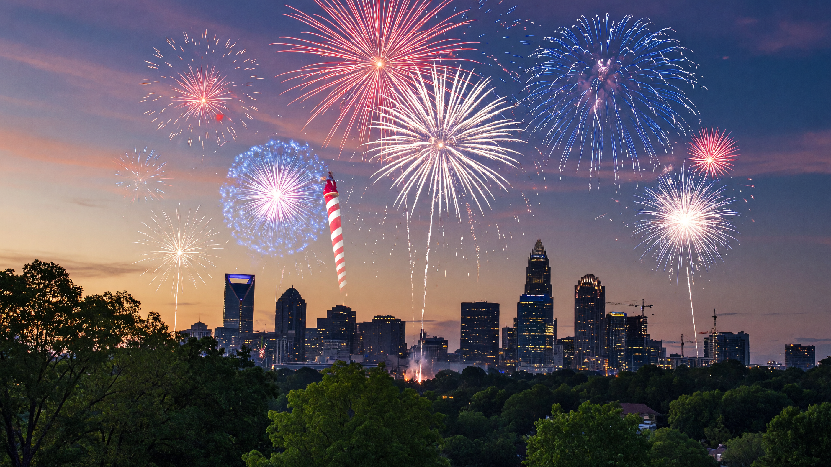 Red white and blue fireworks exploding over the Charlotte NC skyline at dusk on a summer evening