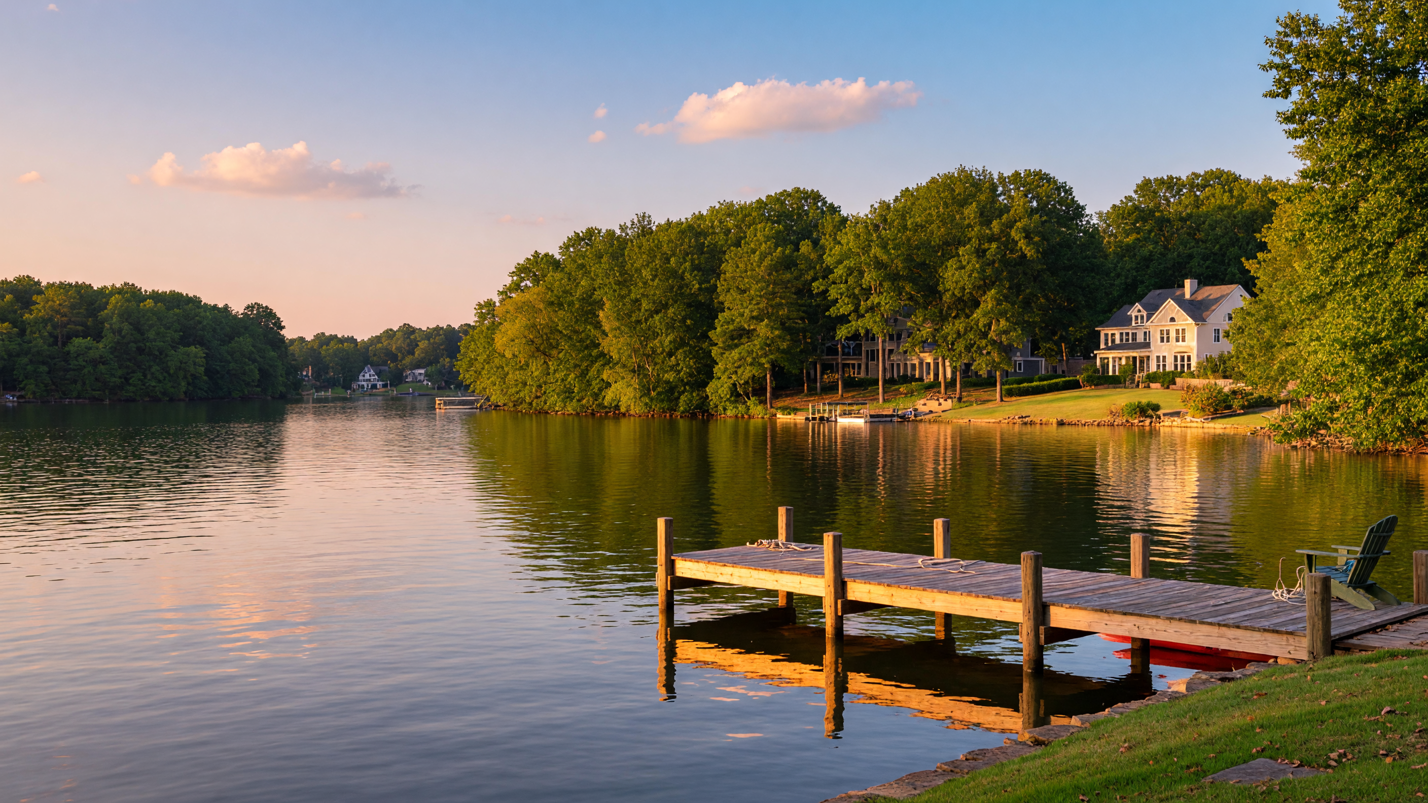 Scenic Lake Norman waterfront at golden hour with calm water, wooden dock, and tree-lined shores in Cornelius NC