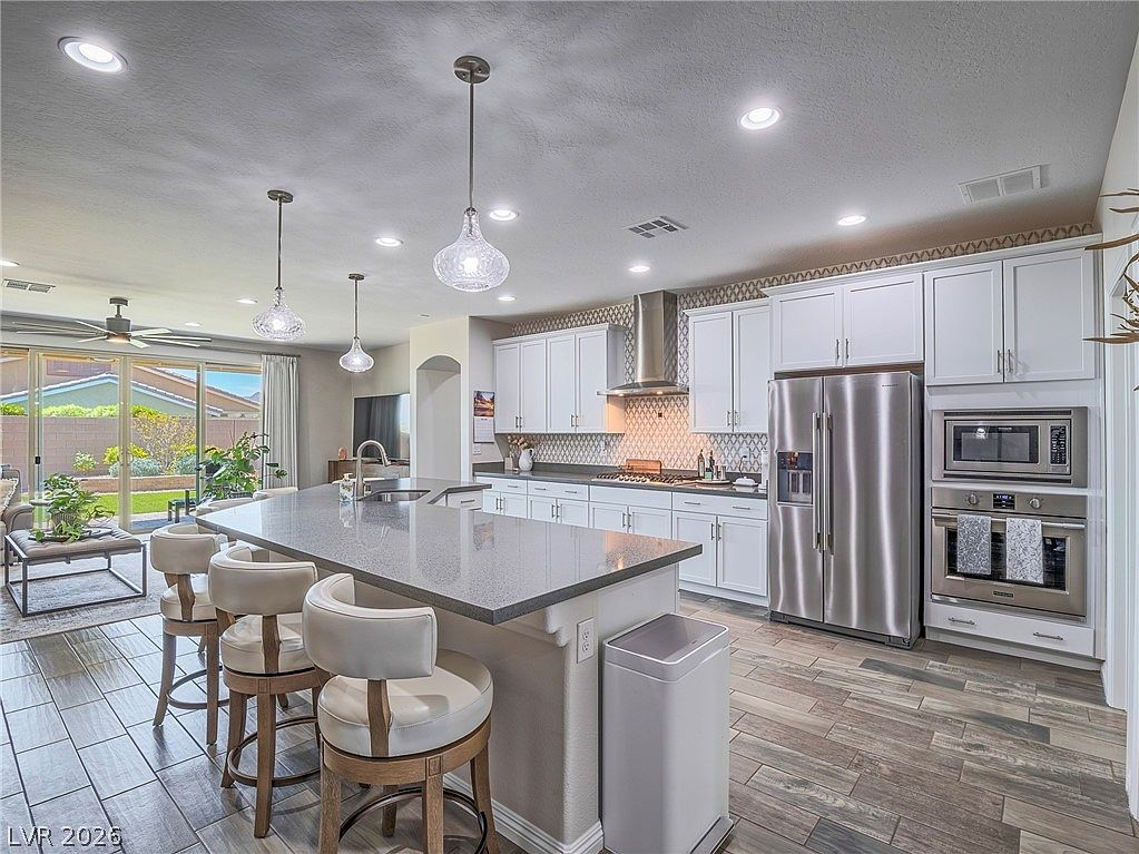 Open-concept kitchen and living area with island and barstools