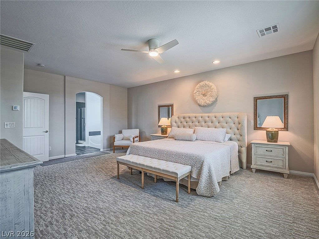 Primary bedroom with ensuite bath archway and neutral tones