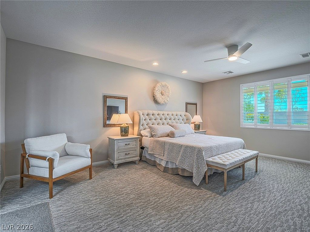 Primary bedroom with carpet, ceiling fan, and natural light
