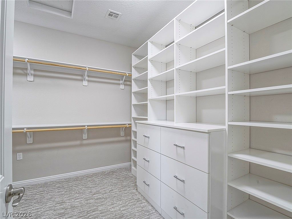 Custom walk-in closet with built-in cabinetry and shelving